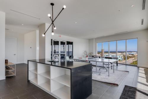 an open kitchen with a dining room and dining table at Modern 4 BR Luxury Condo with Rooftop Pool Next to the Hangout! in Gulf Shores