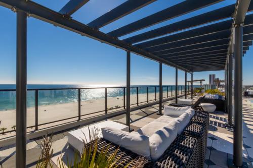 a balcony with white couches and a view of the beach at Modern 4 BR Luxury Condo with Rooftop Pool Next to the Hangout! in Gulf Shores