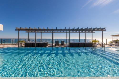 a swimming pool with a view of the ocean at Modern 4 BR Luxury Condo with Rooftop Pool Next to the Hangout! in Gulf Shores