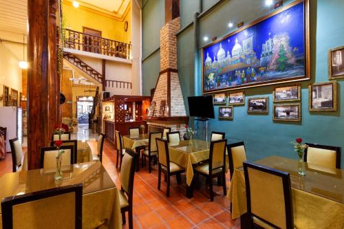un comedor con mesas y sillas en un restaurante en Hotel Majestic 1, en Cuenca
