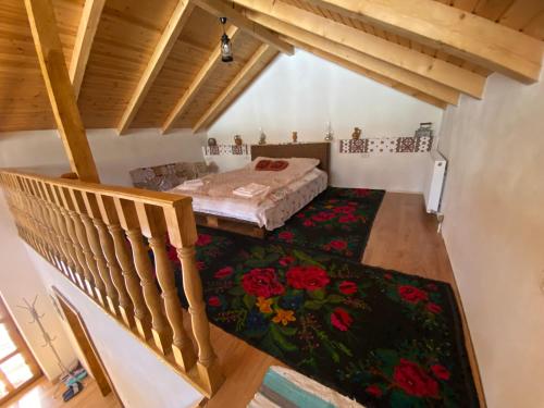an attic room with a bed and a staircase at Pensiunea Casa Țărănească in Satu Bătrîn