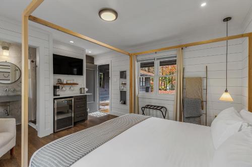 a bedroom with a large white bed and a kitchen at The Wells Cashiers in Cashiers