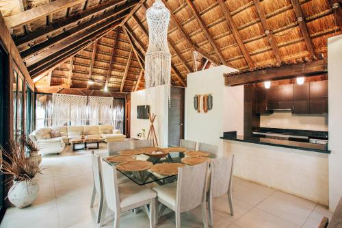 a dining room and living room with a table and chairs at Orchid House Tulum Jungle in Tulum