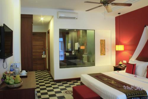 a hotel room with a bed and a mirror at Mekong Angkor Palace Hotel in Siem Reap