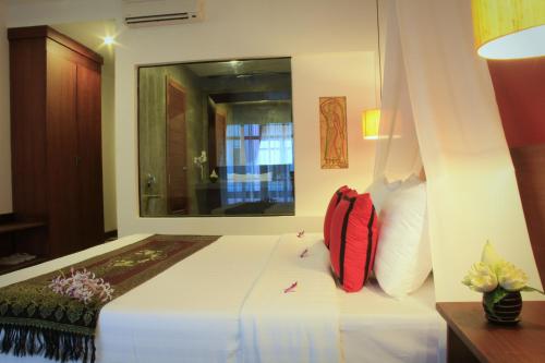 a bedroom with a bed with a red backpack on it at Mekong Angkor Palace Hotel in Siem Reap