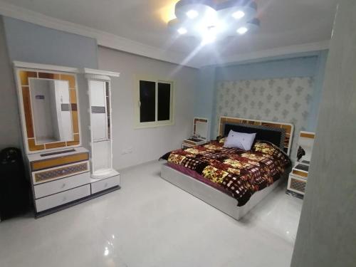 ein Schlafzimmer mit einem Bett, einer Kommode und einem TV in der Unterkunft apartment Mokattam Cairo in Kairo