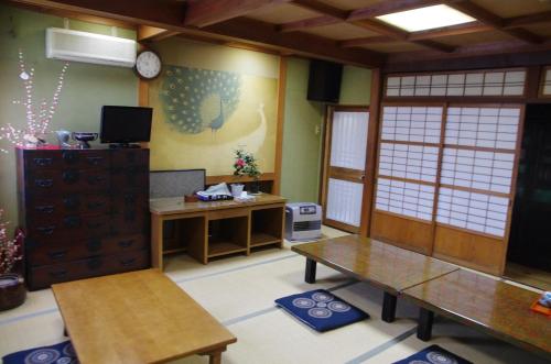 una camera con due tavoli e una scrivania di Ryokan Takayama a Takayama