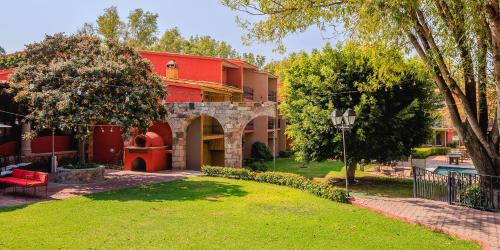 a red building with a yard in front of it at Real de Minas San Miguel de Allende in San Miguel de Allende