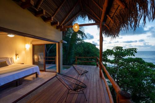 a bedroom with a bed and a view of the ocean at Punta Monterrey in Lo de Marcos