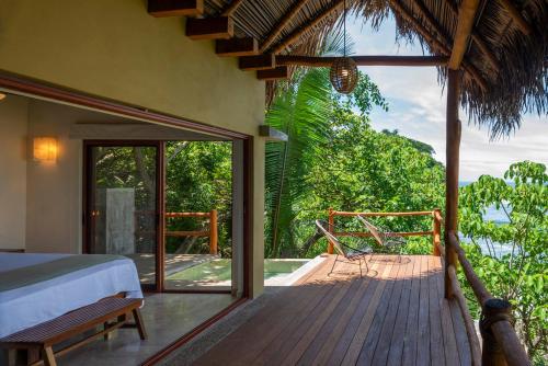 a room with a bed and a balcony with a view at Punta Monterrey in Lo de Marcos