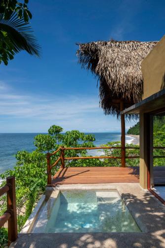 a resort with a small swimming pool next to the ocean at Punta Monterrey in Lo de Marcos