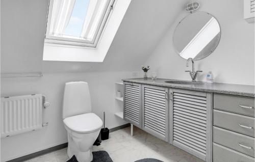y baño con aseo, lavabo y espejo. en Lovely Apartment In Nex With Wifi, en Neksø