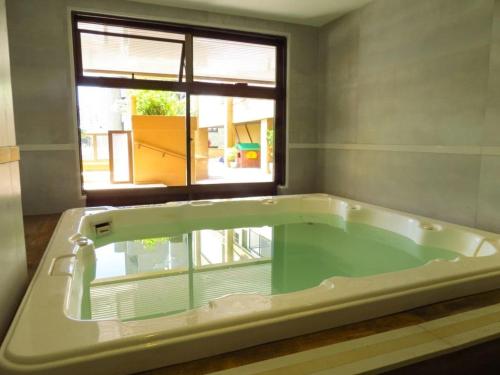 bañera grande en una habitación con ventana en Apart Hotel Barra Leme com Vista Mar e Montanha B1-001, en Río de Janeiro