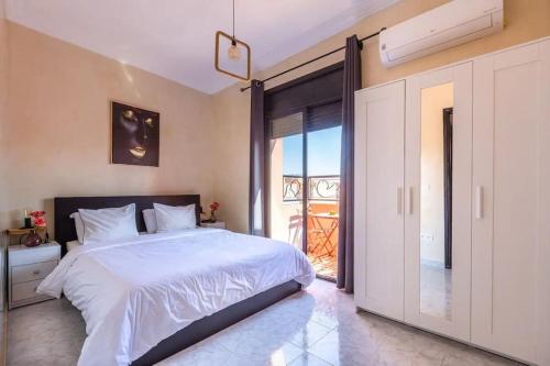 a bedroom with a white bed and a balcony at Gueliz, Plaza, Zara in Marrakesh