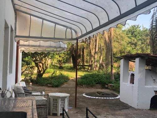 a patio with a white pergola and a fireplace at Casa na Serra - em meio à um bosque c Ofurô aquecido in Jarinu