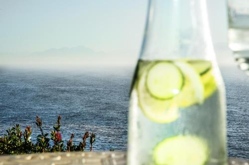 a close up of a bottle with a view of the ocean at Rocklands Seaside Bed and Breakfast in Simonʼs Town