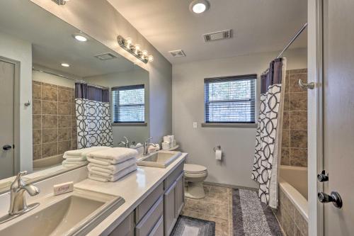 a bathroom with a sink and a tub and a toilet at Le Bleu, Bright Hodgen Home with Fire Pit and Views! in Hodgen