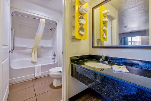 a bathroom with a sink and a toilet and a mirror at Motel 6-Arlington, TX in Arlington