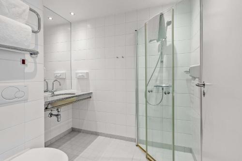 a bathroom with a shower and a toilet and a sink at Best Western Hotel Hillerød in Hillerød