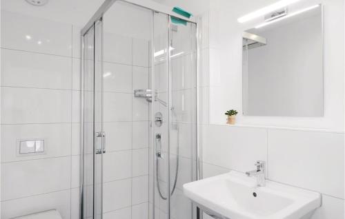 ein weißes Bad mit einer Dusche und einem Waschbecken in der Unterkunft Stunning Apartment In Ostseeresort Olpenitz With 2 Bedrooms, Wifi And Sauna in Olpenitz