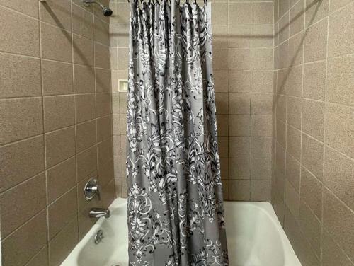 a shower curtain in a bathroom with a bath tub at Motel 6 Richmond CA Civic Center in Richmond