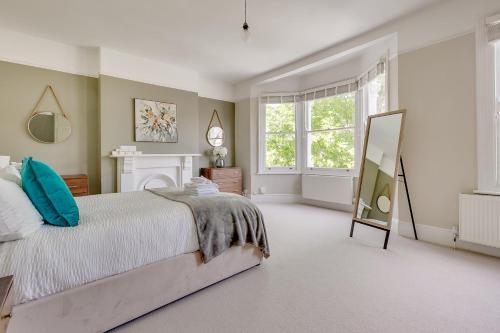 - une chambre avec un grand lit et un miroir dans l'établissement Boutique Victorian 4 Bed House with Garden in Balham, à Londres