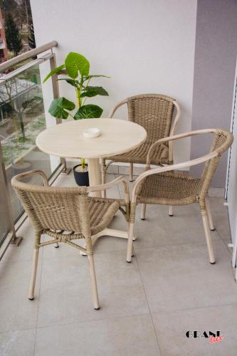 a table and two chairs and a table and a table at GRAND LUX Apartment in Doboj