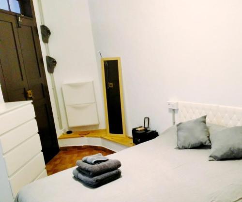 Un dormitorio con una cama blanca con toallas. en La Pernocta, en Arucas