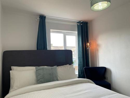 a bedroom with a bed with a window and a chair at Luxury 4 Large Bedrooms Thurrock Grays 3 bathrooms 1 en suite Netflix Free Parking in Grays Thurrock