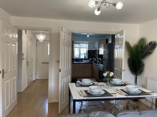 a dining room with a table and a kitchen at Luxury Large Beds in West Thurrock 3 bathrooms 1 en suite Netflix Free Parking in Grays Thurrock