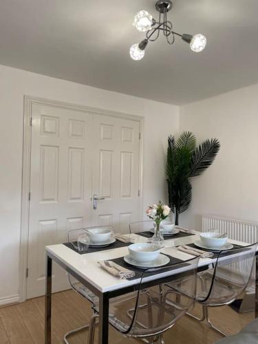 a dining room table with bowls and plates on it at Luxury 4 Large Bedrooms Thurrock Grays 3 bathrooms 1 en suite Netflix Free Parking in Grays Thurrock