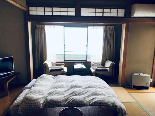 a bedroom with a bed and a large window at 金閣莊 private onsen by reservation for free in Hakone