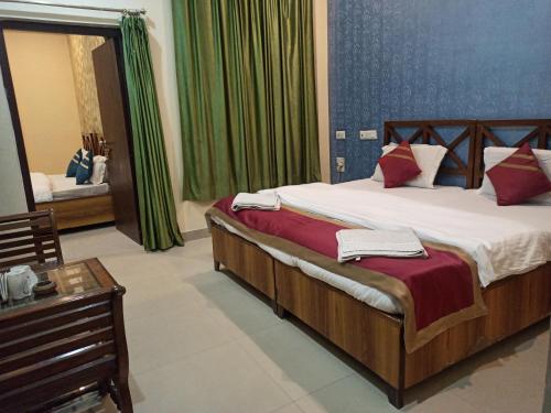 a bedroom with a large bed and a table at Dudhwa TigeRhino Resort in Dudwa