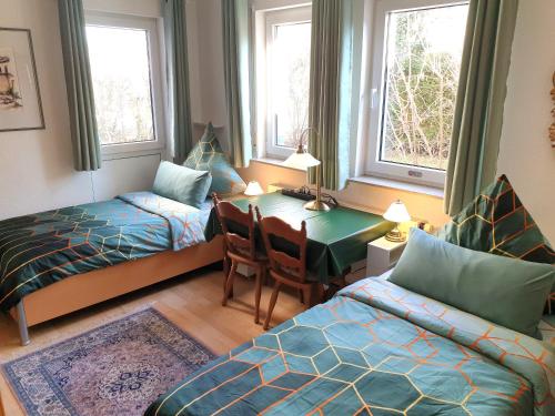 ein Schlafzimmer mit einem Tisch, einem Bett und einem Schreibtisch in der Unterkunft Zimmer Hohbuch mit Achalmblick in Reutlingen
