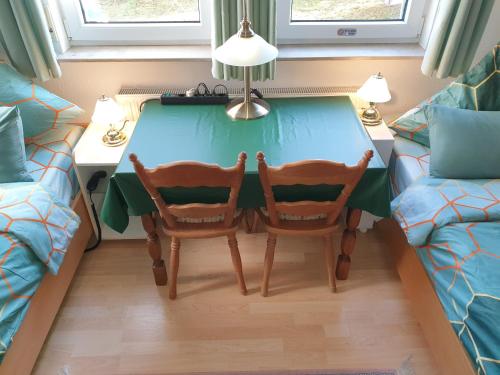 ein Zimmer mit einem Tisch, 2 Stühlen und einem Sofa in der Unterkunft Zimmer Hohbuch mit Achalmblick in Reutlingen