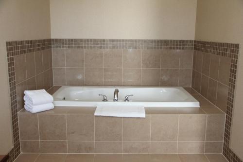 eine Badewanne im gefliesten Bad mit Waschbecken in der Unterkunft Staybridge Suites London, an IHG Hotel in London