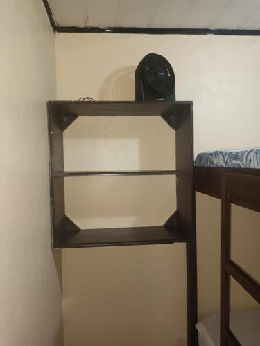 a shelf in a room with a clock on it at Apartamentos Caimán Tortuguero in Tortuguero