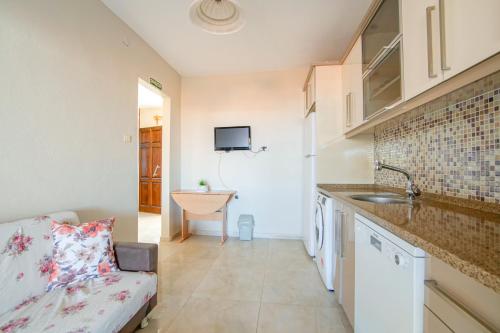 eine Küche mit Sofa und Waschbecken in einem Zimmer in der Unterkunft ÇUHADAR AHŞAP EVLERİ in Datca