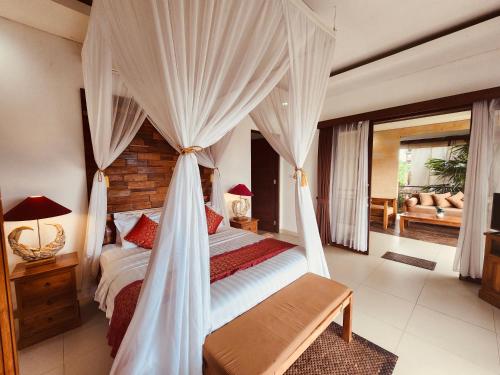 1 dormitorio con 1 cama con dosel en Uma Padi Villa, en Ubud
