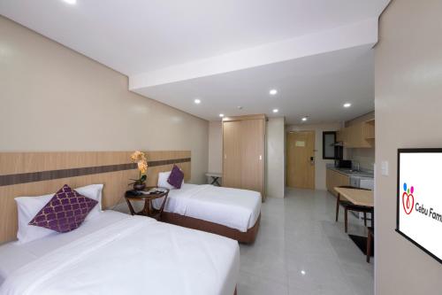 a hotel room with two beds and a kitchen at Cebu Family Suites powered by Cocotel in Cebu City