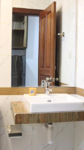 a bathroom with a white sink and a mirror at Ptas Tauch Residence in Phnom Penh