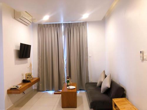 a living room with a couch and a tv at Ptas Tauch Residence in Phnom Penh