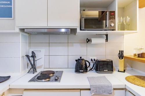 a kitchen with a stove and a microwave at San Carlos rentals - Lastarria in Santiago