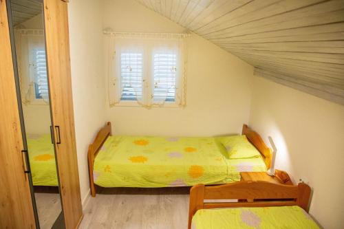 a small bedroom with a bed and a window at Apartments by the sea Milna, Vis - 8895 in Rukavac