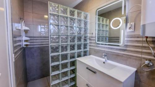 a bathroom with a sink and a shower and a mirror at Apartments by the sea Milna, Vis - 8895 in Rukavac