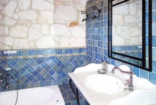 a blue tiled bathroom with two sinks and a mirror at Ira Agios Leon Zakynthos in Agios Leon