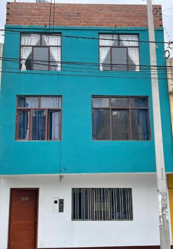 un edificio azul y blanco con ventanas y una puerta en Home Mariana, en Trujillo