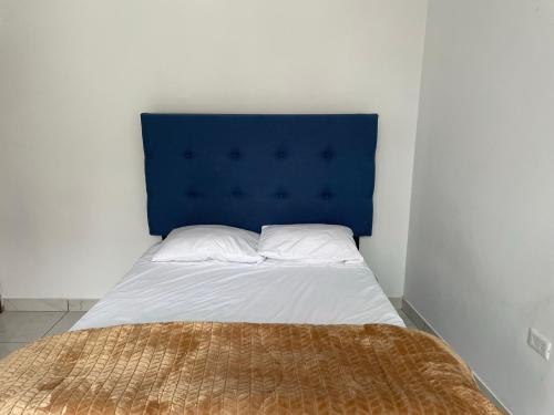 1 cama con cabecero azul en una habitación en Home Mariana, en Trujillo