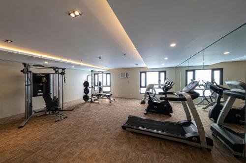 un gimnasio con cintas de correr y equipo cardiovascular en una habitación en Cebu Family Suites powered by Cocotel en Cebu City
