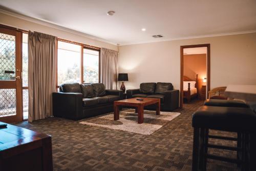 ein Wohnzimmer mit einem Sofa und einem Tisch in der Unterkunft Riverbush Cottages in Monash